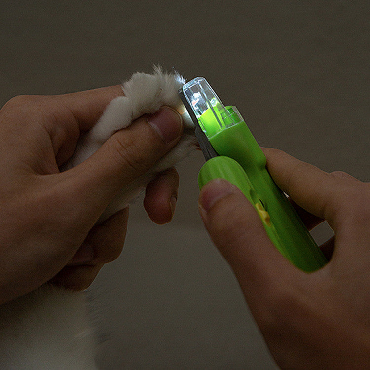 Cactus-Shaped Multi-Function Pet Nail Clipper being used to trim a pet's nails with a white light.